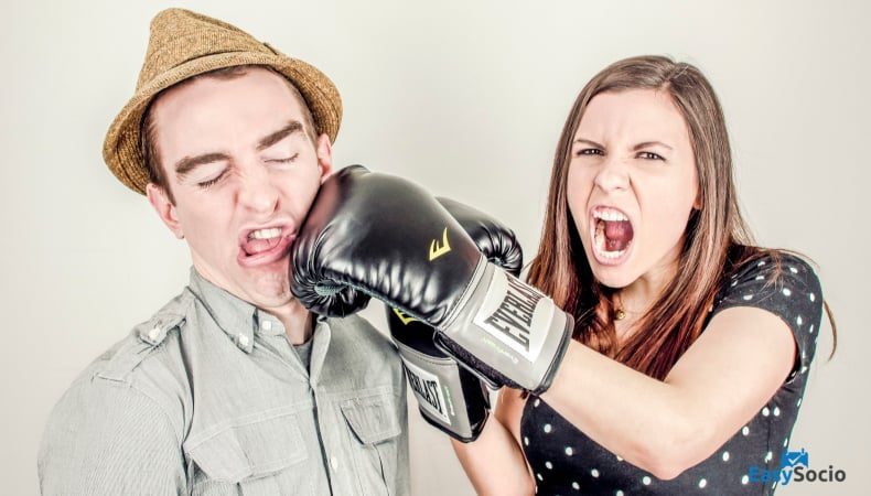 angry girl punching a guy with boxing gloves